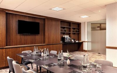 Professional meeting room with TV screen and coffee maker at the Hilton Birmingham Metropole.