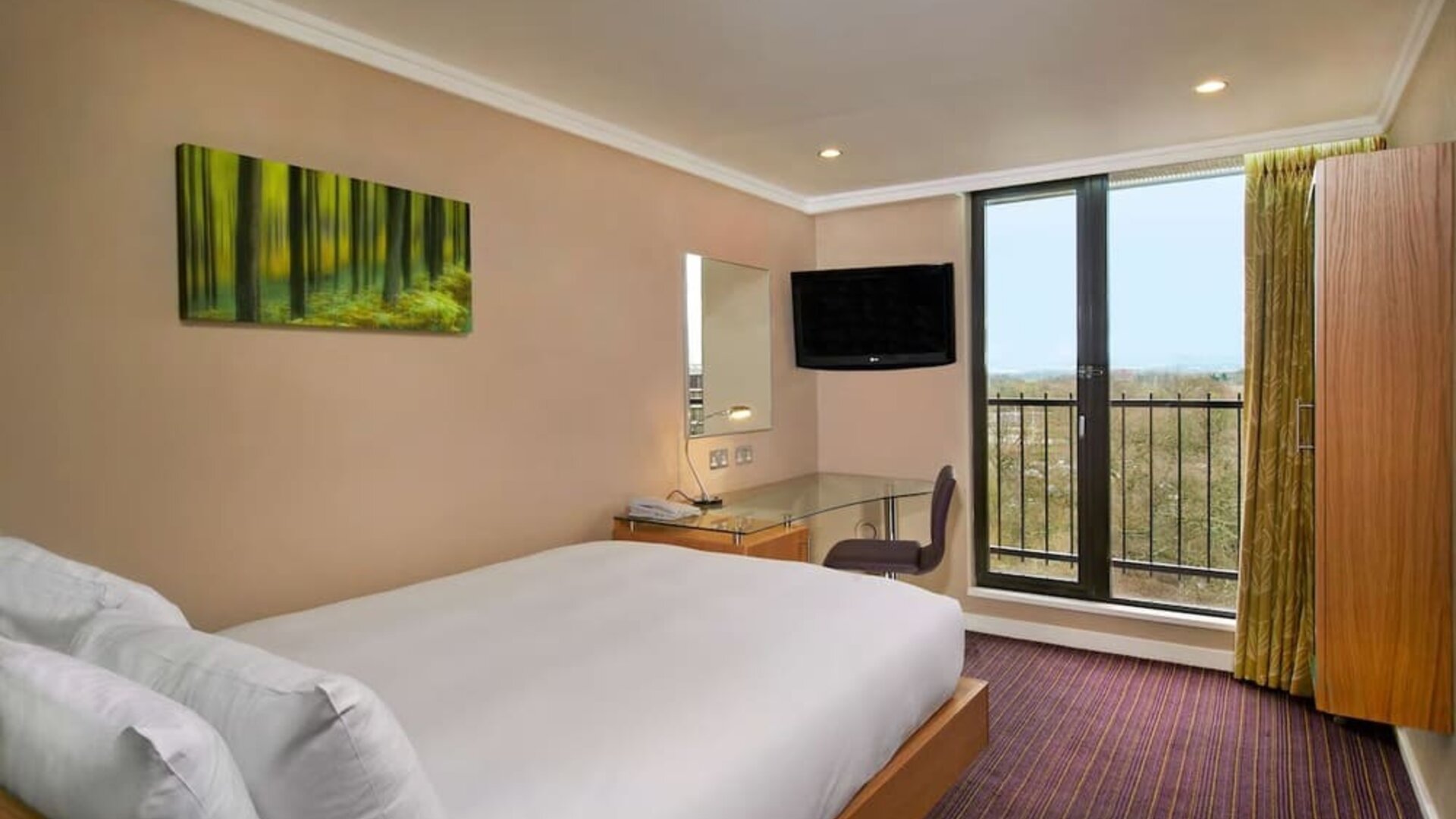 Single room with work desk, TV screen, closet and balcony at the Hilton Birmingham Metropole.