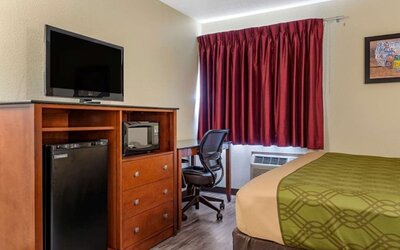 Day room with TV and fridge at Coratel Inn & Suites By Jasper River Falls.