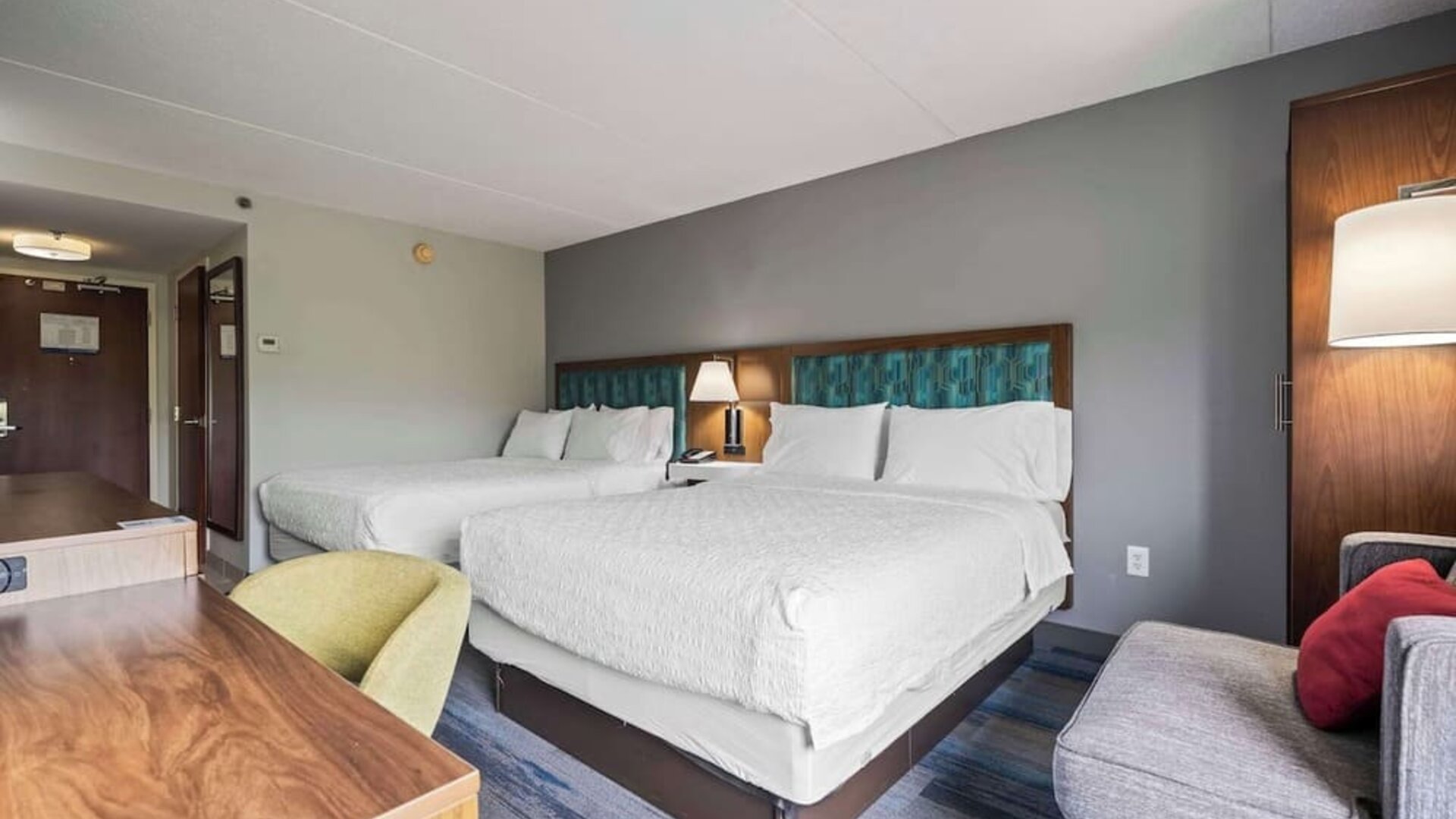 Double Queen guest room featuring two comfortable beds, modern furnishings, ample workspace, and thoughtful amenities for families or groups at Hampton Inn Ridgefield Park.