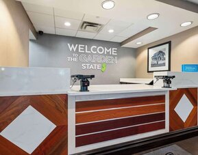 Modern reception desk featuring friendly check-in services and a welcoming lobby atmosphere at Hampton Inn Ridgefield Park.
