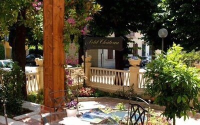 Peaceful outdoor terrace with garden seating surrounded by lush greenery, perfect for enjoying breakfast or relaxing outdoors.
