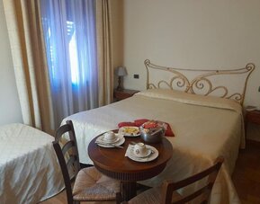 Spacious guest room with one double bed and one single bed, ideal for families or small groups.