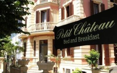 Exterior view of Petit Chateau showcasing its elegant villa architecture, landscaped gardens, and welcoming entrance.