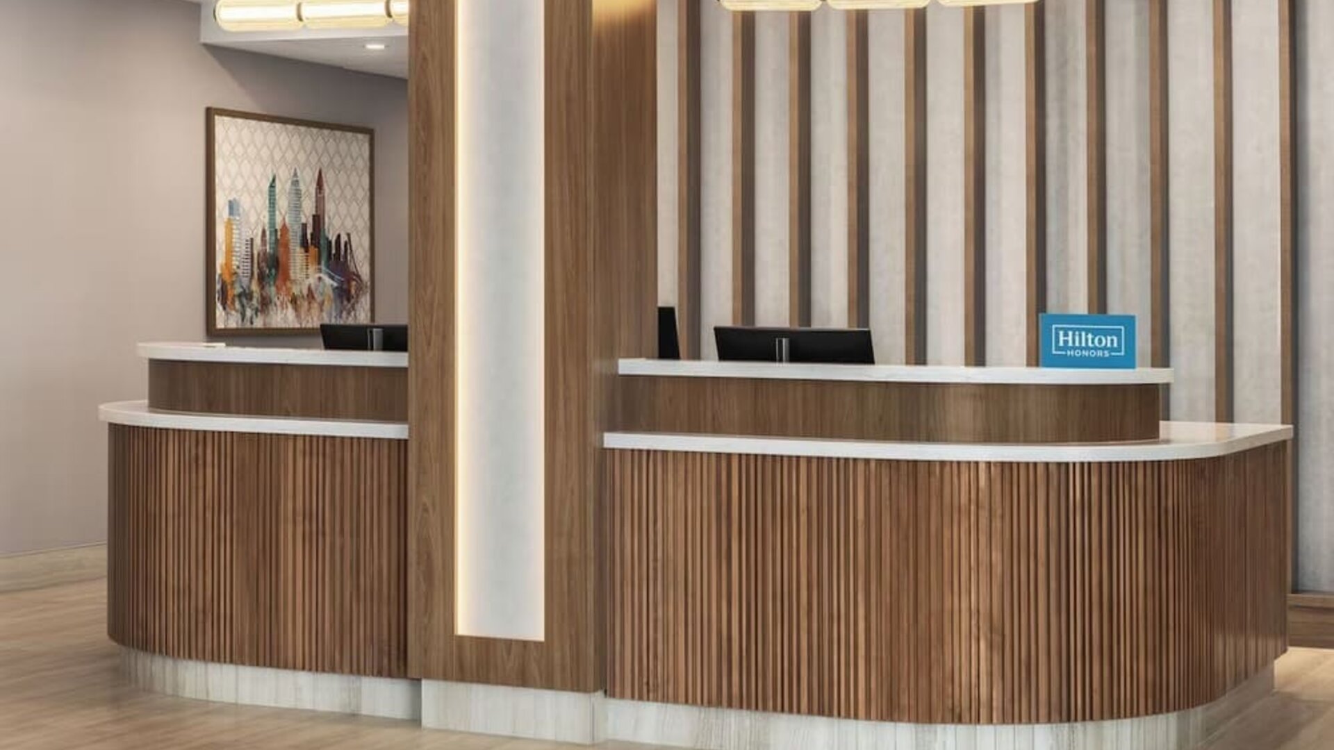 Reception desk with wood paneling, Hilton Honors signage, and contemporary lighting at Hampton Inn By Hilton Montreal East Anjou.