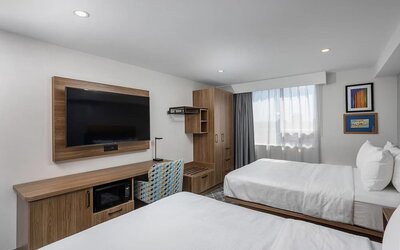 Guest room with two queen beds, large television, work desk, and wood furnishings at Hampton Inn By Hilton Montreal East Anjou.