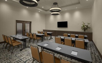 Meeting room with classroom-style seating, wall-mounted television, and flexible event space at Hyatt Place Bozeman Yellowstone Airport.