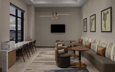 Business lounge with workstations, lounge seating, and wall-mounted television at Hyatt Place Bozeman Yellowstone Airport.