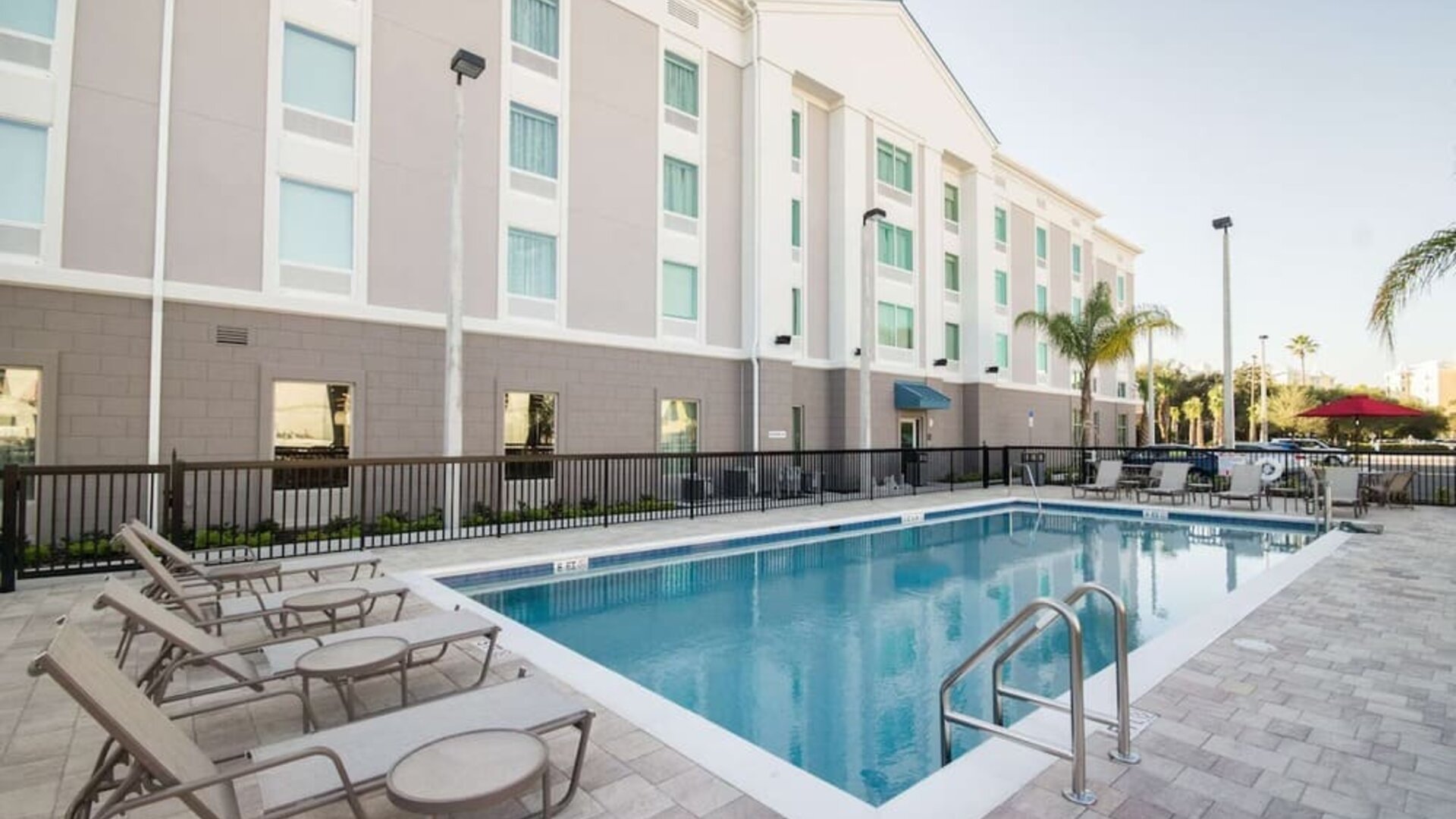 Outdoor swimming pool with lounge chairs and spacious sun deck at Hampton Inn & Suites Orlando at SeaWorld.