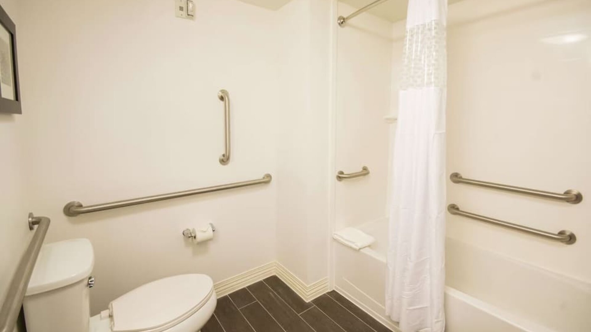 Accessible bathroom with bathtub, grab bars, and mobility-friendly layout at Hampton Inn & Suites Orlando at SeaWorld.