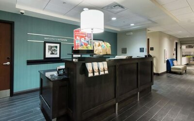 Front desk with guest services counter and modern lobby entrance at Hampton Inn & Suites Orlando at SeaWorld.