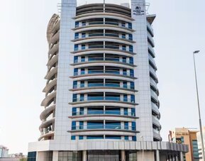 Contemporary high-rise hotel building with curved architectural design, glass windows, and city surroundings.