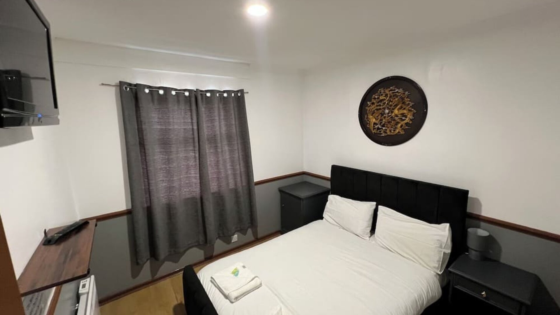 Spacious guest room with double bed, flat-screen television, and modern furnishings at Stay Inn Express.
