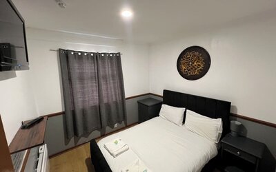 Spacious guest room with double bed, flat-screen television, and modern furnishings at Stay Inn Express.