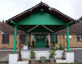 Hotel front entrance with covered porte-cochère and landscaped entrance at Stay Inn Express.