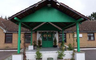 Hotel front entrance with covered porte-cochère and landscaped entrance at Stay Inn Express.