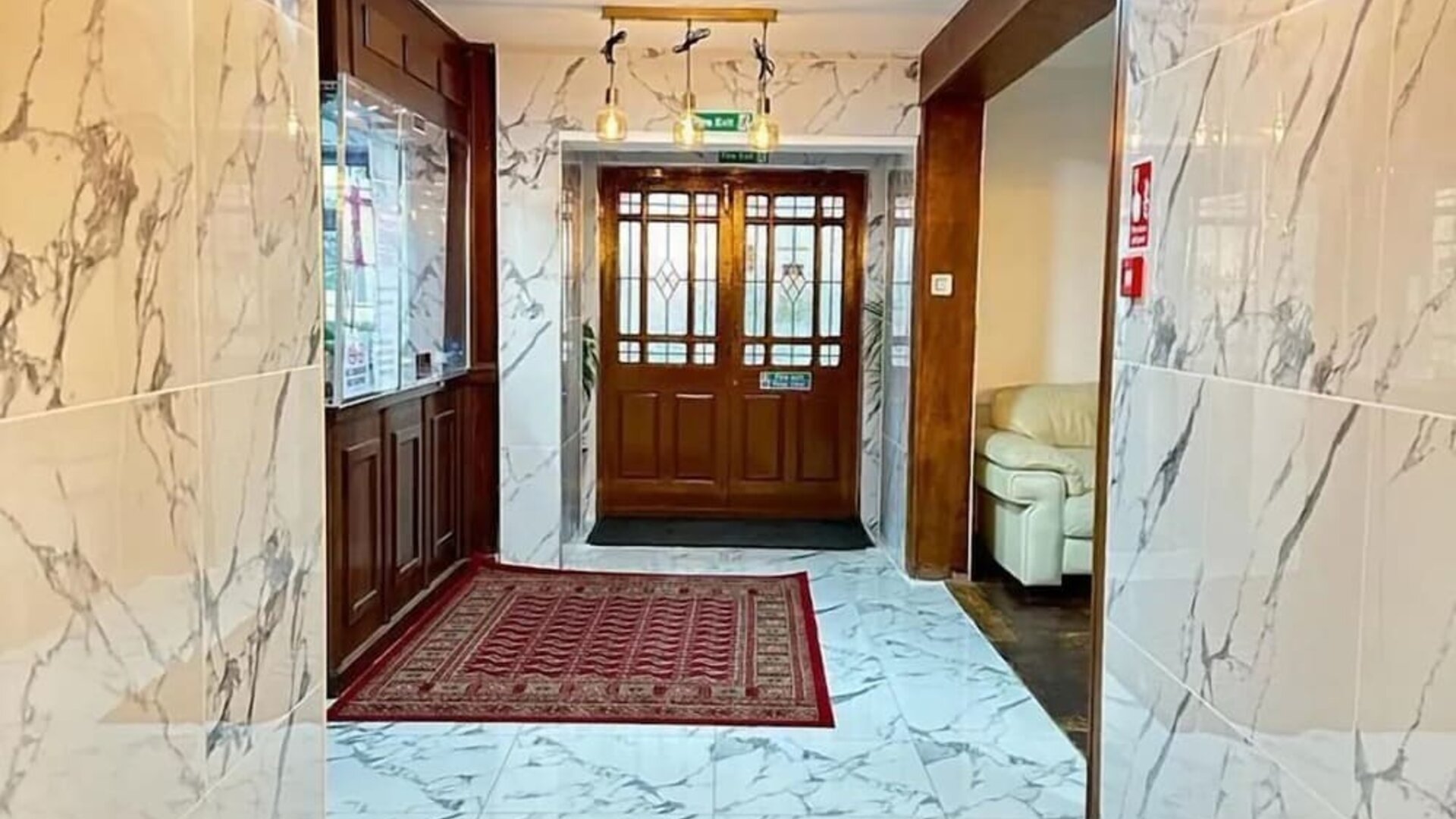 Hotel lobby with marble-style flooring, elegant lighting, and comfortable seating at Stay Inn Express.