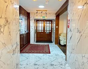 Hotel lobby with marble-style flooring, elegant lighting, and comfortable seating at Stay Inn Express.