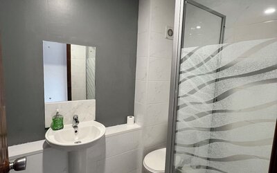 Bathroom with walk-in shower, pedestal sink, and modern finishes at Stay Inn Express.