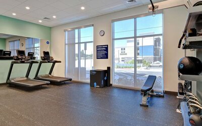 Fitness center with treadmills, free weights, and strength training equipment at Tru By Hilton Lithia Springs.