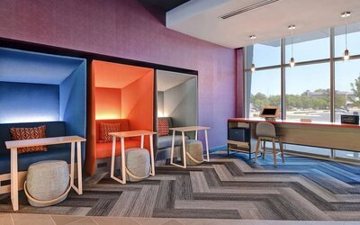 Business center with private work pods, desks, and large windows at Tru By Hilton Lithia Springs.