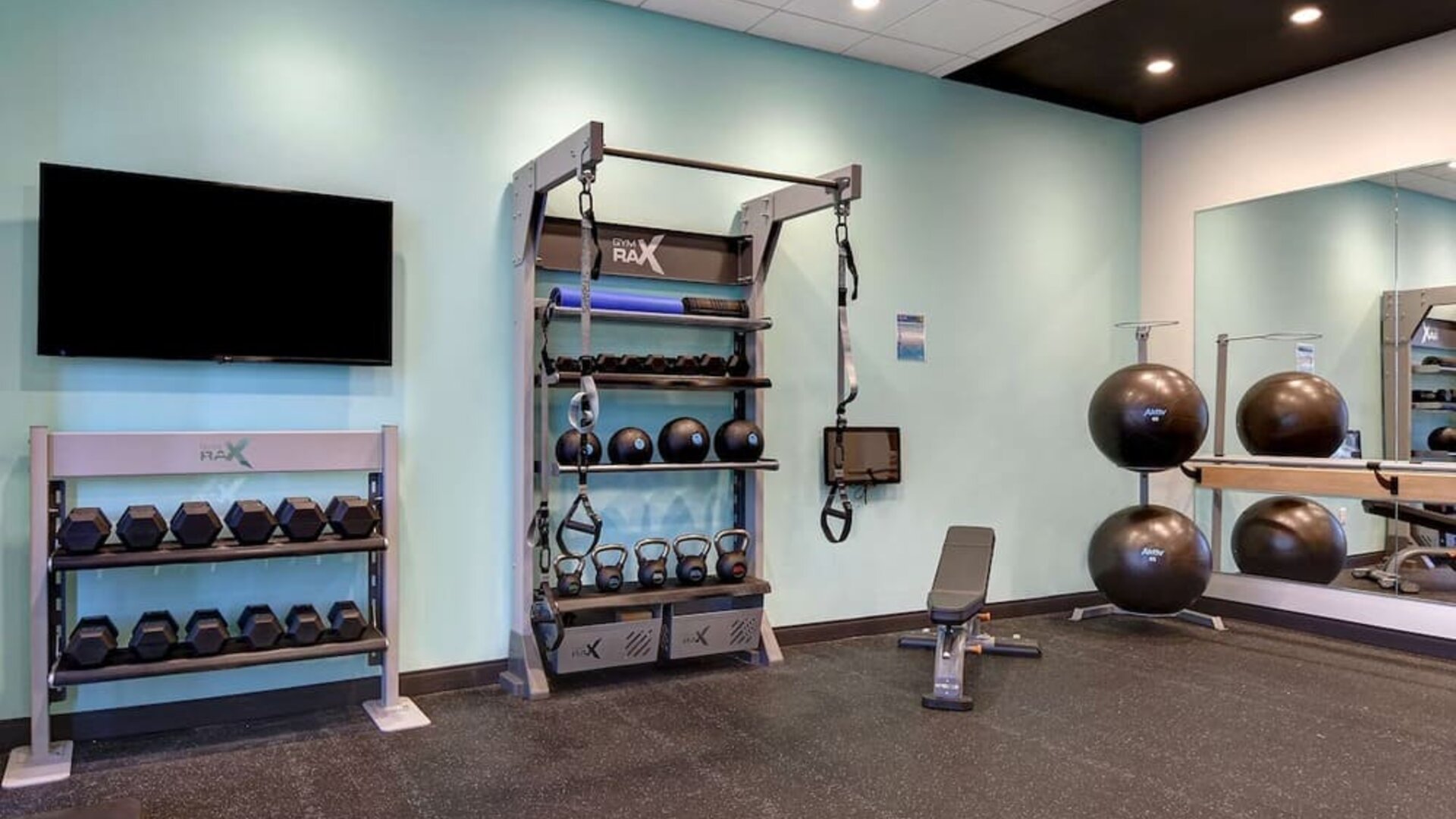 Modern fitness facility featuring dumbbells, kettlebells, suspension trainers, and exercise equipment at Tru By Hilton Lithia Springs.