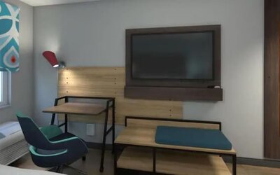 Guest room workspace with desk, lounge seating, flat-screen TV, and modern furnishings at Tru By Hilton Lithia Springs.