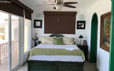 Spacious bedroom with king-size bed, private balcony, and contemporary coastal décor at Casa Playa Baja Resort.