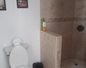 Bathroom with walk-in stone shower, toilet, and modern fixtures at Casa Playa Baja Resort.