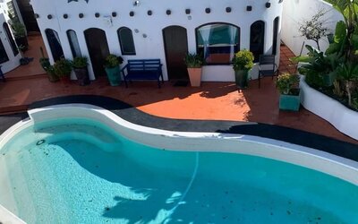 Outdoor swimming pool surrounded by resort accommodations and tropical landscaping at Casa Playa Baja Resort.