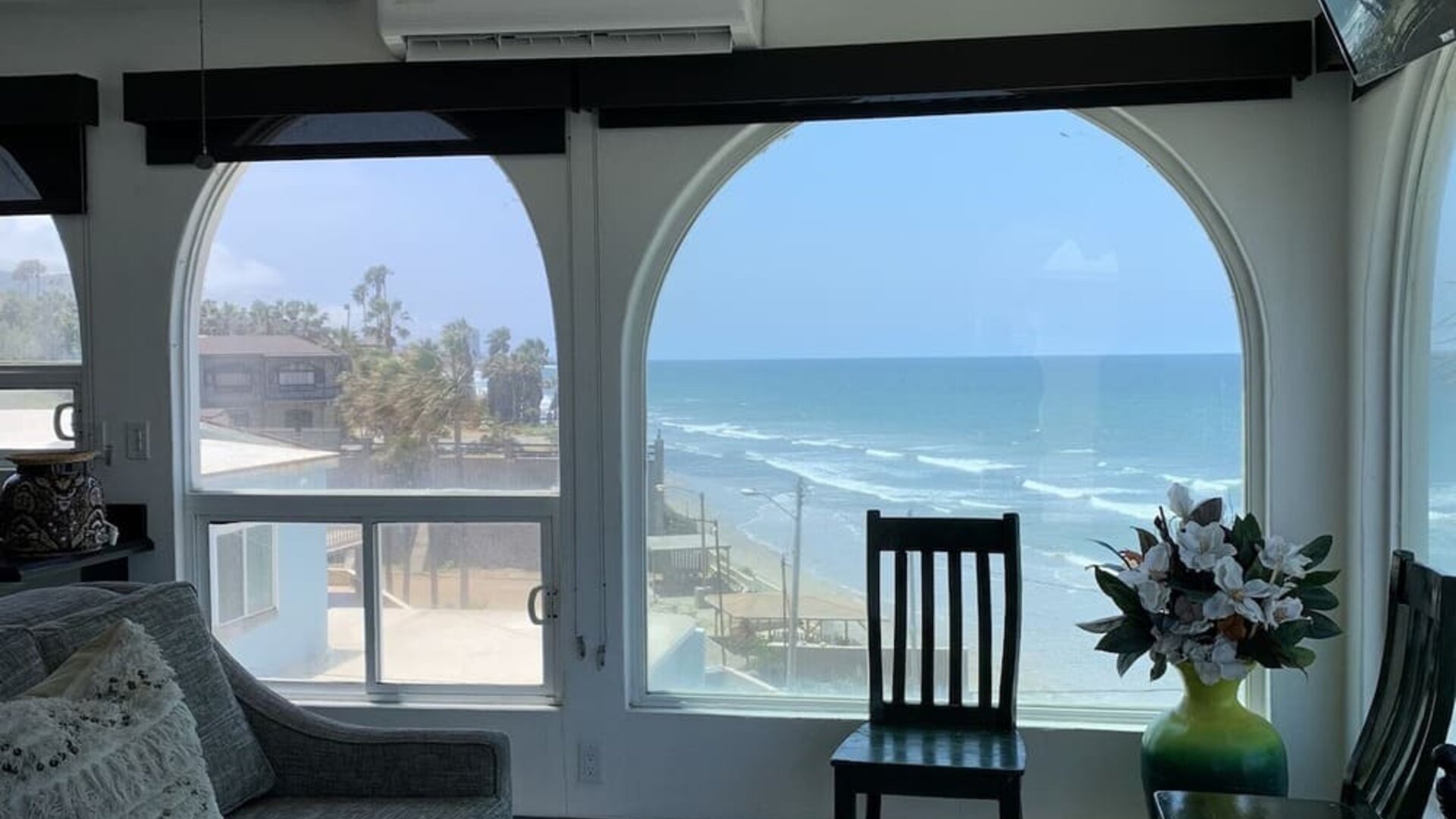 Living area with ocean-view windows, seating, and coastal-inspired interiors at Casa Playa Baja Resort.