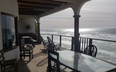 Covered beachfront terrace with outdoor dining and unobstructed ocean views at Casa Playa Baja Resort.
