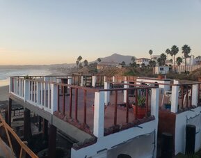 Rooftop terrace overlooking the coastline with outdoor seating and panoramic ocean views at Casa Playa Baja Resort.