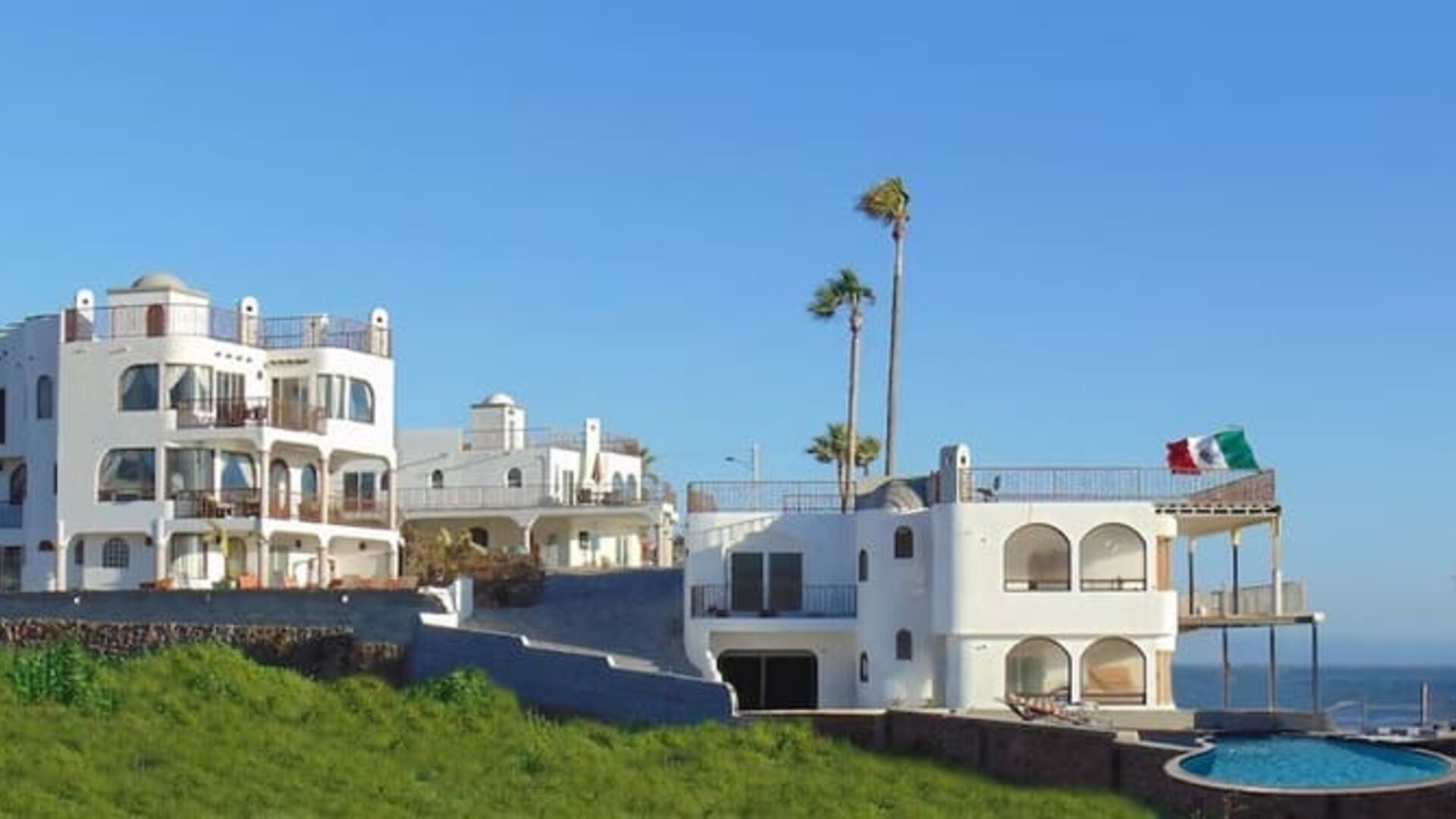 Panoramic exterior view of the beachfront resort, swimming pool, and Pacific coastline at Casa Playa Baja Resort.