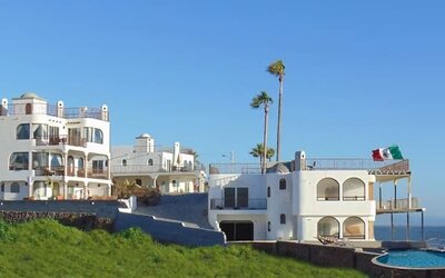 Panoramic exterior view of the beachfront resort, swimming pool, and Pacific coastline at Casa Playa Baja Resort.