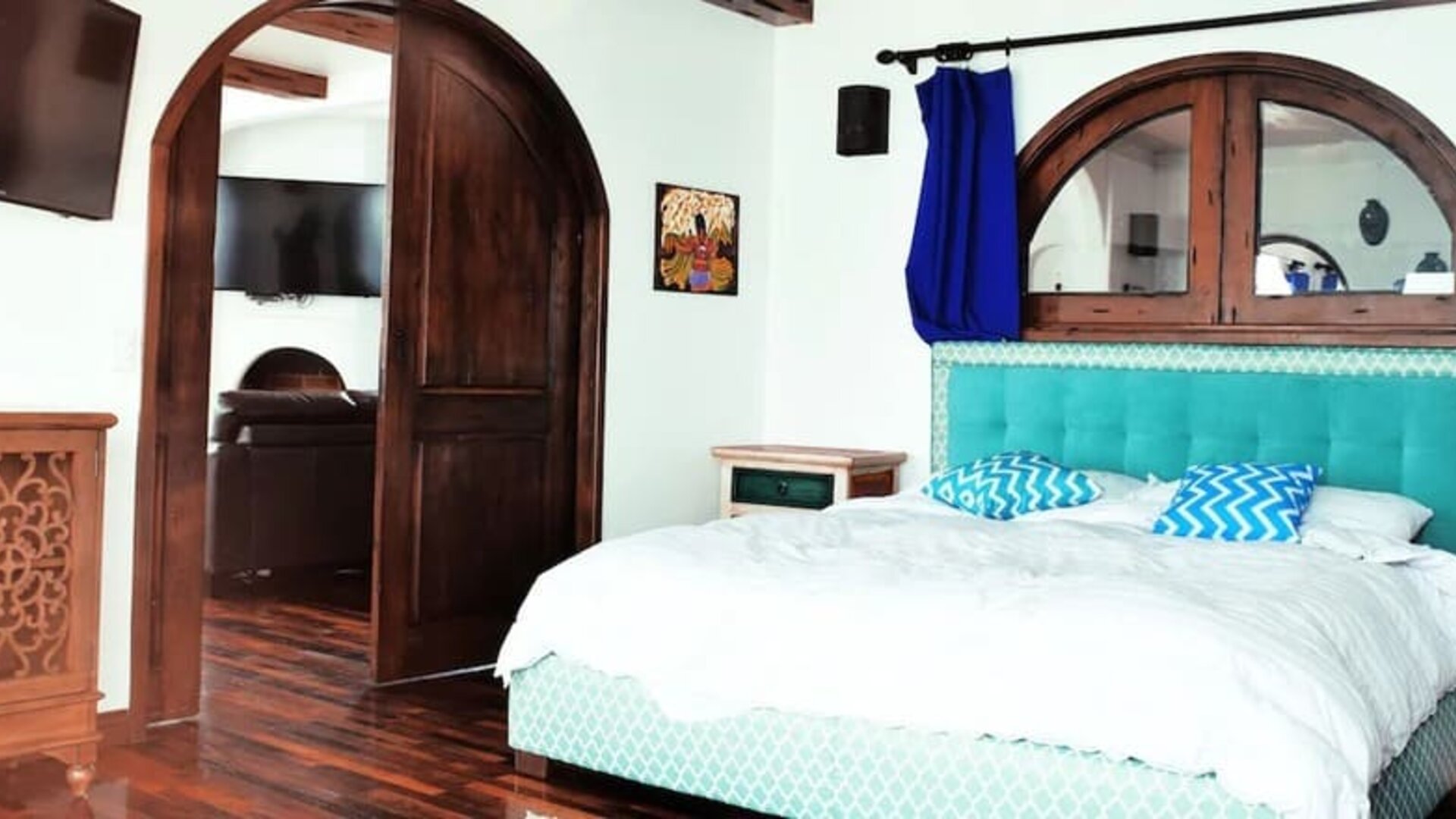 Bright king suite with green accents, large windows, balcony access, and modern furnishings at Casa Playa Baja Resort.