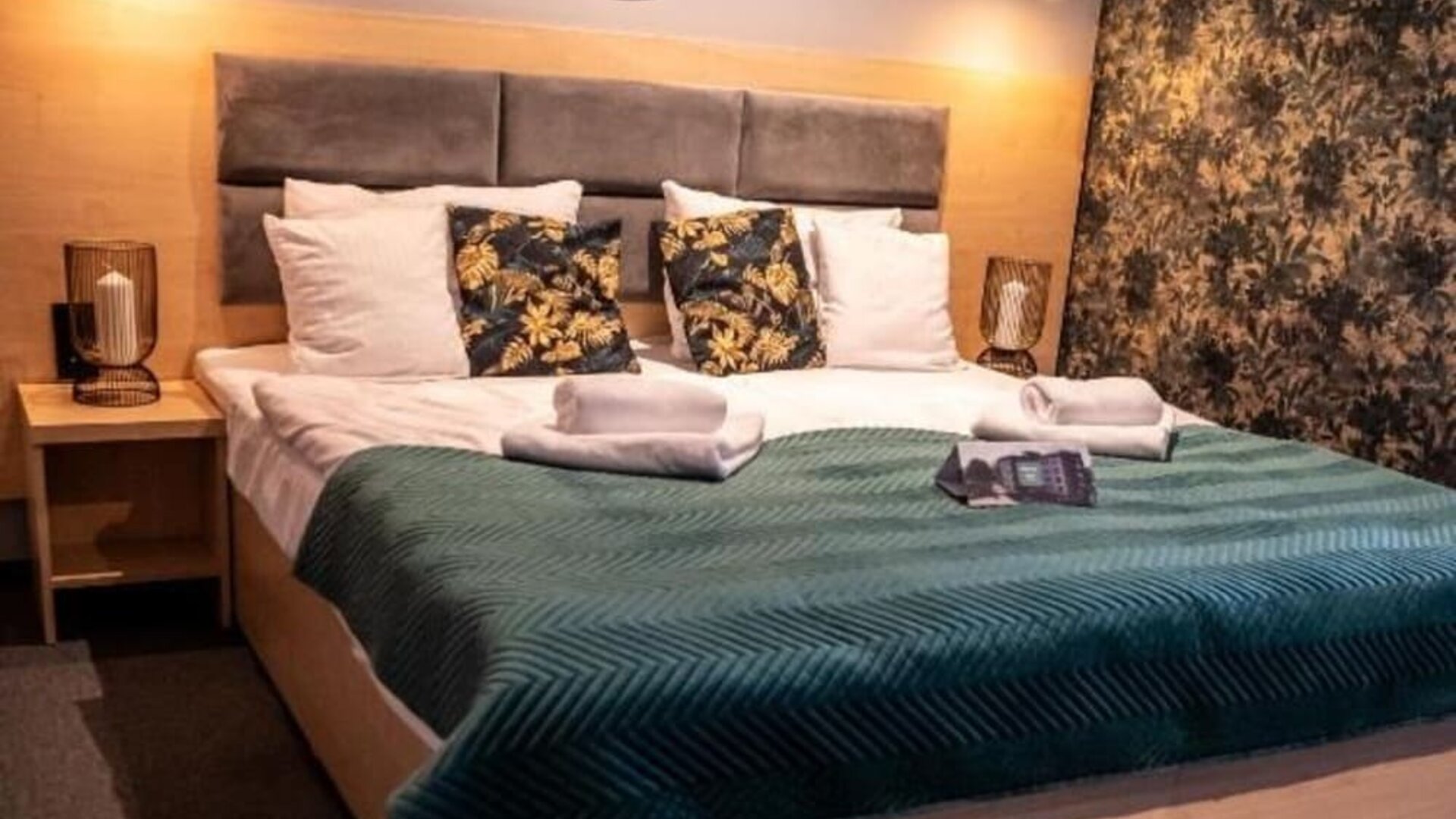 Contemporary king guest room with feature lighting and botanical wallpaper at Hotel Seven.