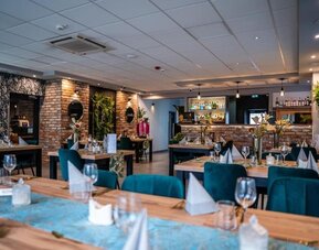 Elegant restaurant with modern tables, velvet chairs and exposed brick accents at Hotel Seven.