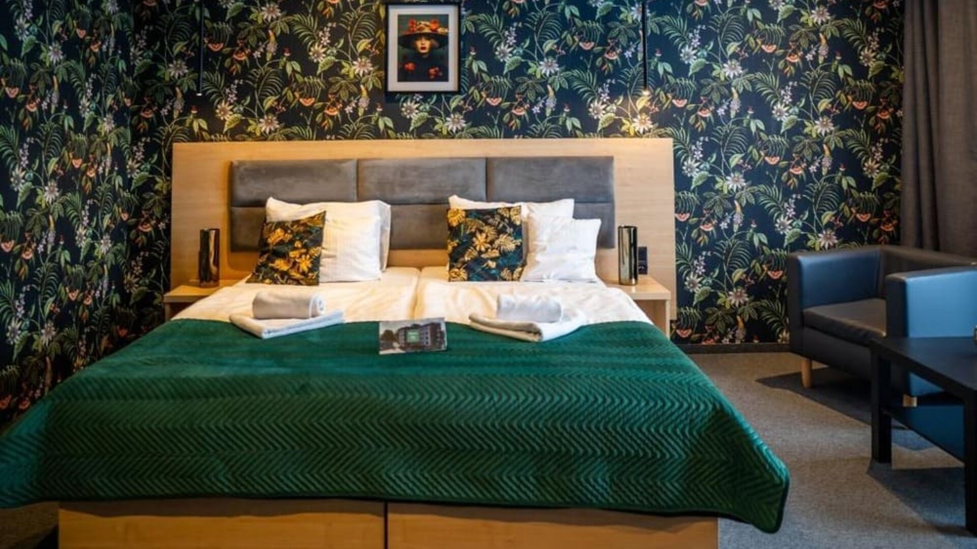 Stylish guest room with king-size bed, botanical feature wall and comfortable seating at Hotel Seven.