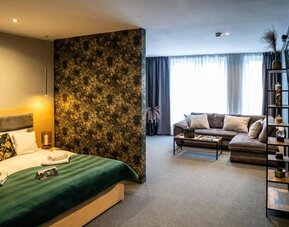 Spacious suite with king-size bed, separate living area and contemporary décor at Hotel Seven.