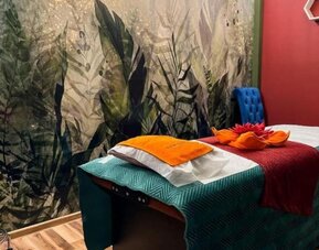 Spa treatment room with massage table, botanical mural and relaxing atmosphere at Hotel Seven.