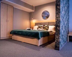 Spacious Hotel Seven bedroom with king-size bed, modern wardrobe and elegant décor.