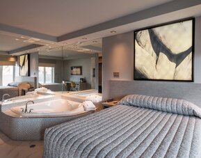 Spacious suite with king-size bed, in-room jacuzzi and contemporary décor at Le Chabrol Hotel Et Suites.