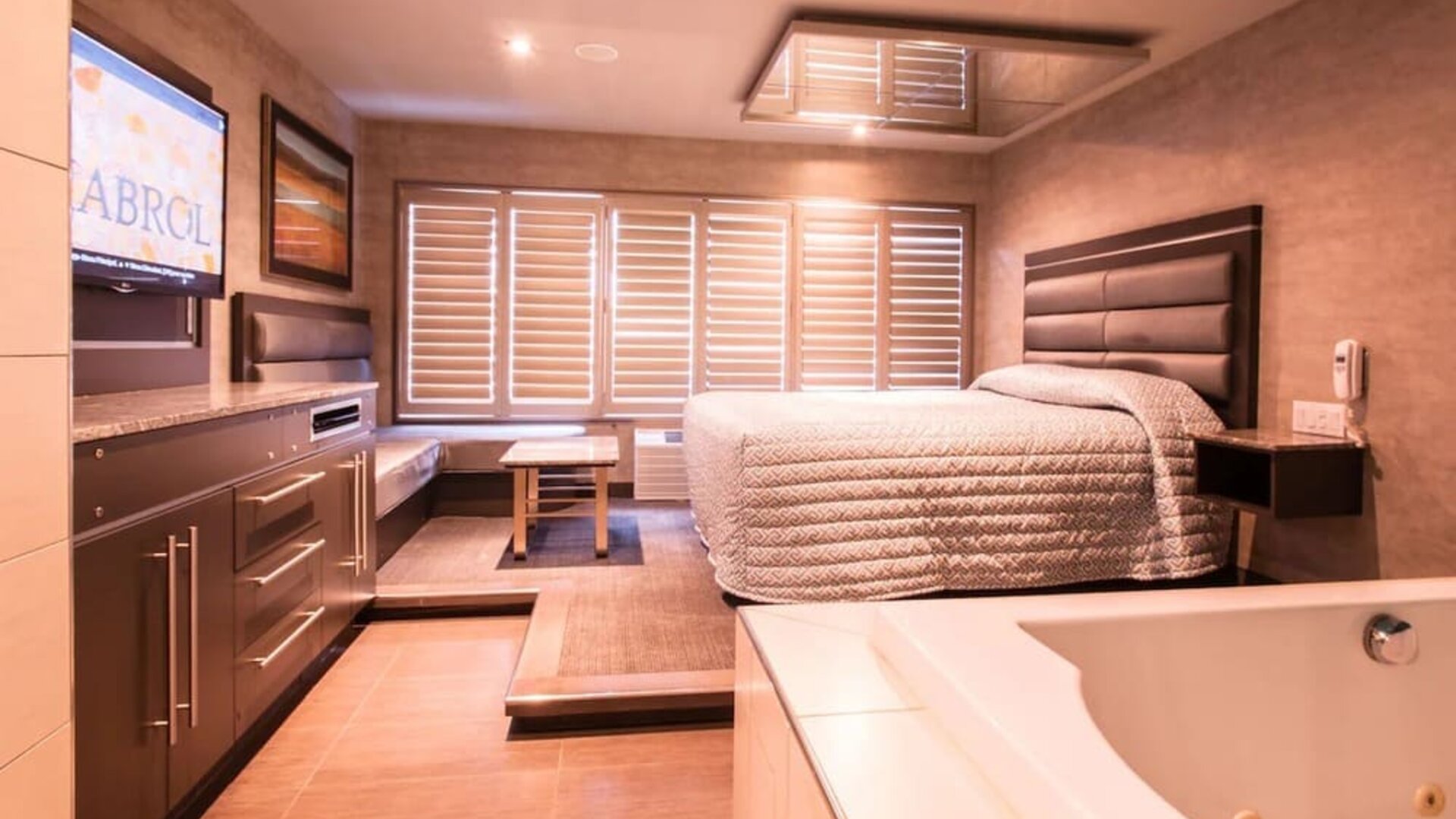 Spacious suite with king-size bed, in-room jacuzzi and seating area at Le Chabrol Hotel Et Suites.
