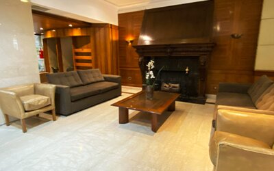 Sophisticated lounge area with comfortable sofas, armchairs, a decorative fireplace, and classic wood-paneled interiors ideal for relaxation at Hotel Lafayette.