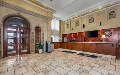 Welcoming hotel reception area with front desk and spacious lobby at Hotel Brossard.