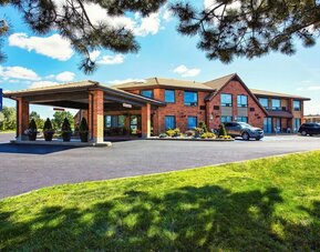 Exterior view of Comfort Inn Laval featuring convenient parking and covered entrance.