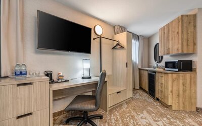 Guest room workspace with desk, kitchenette, microwave, mini fridge and coffee station at Comfort Inn Laval.