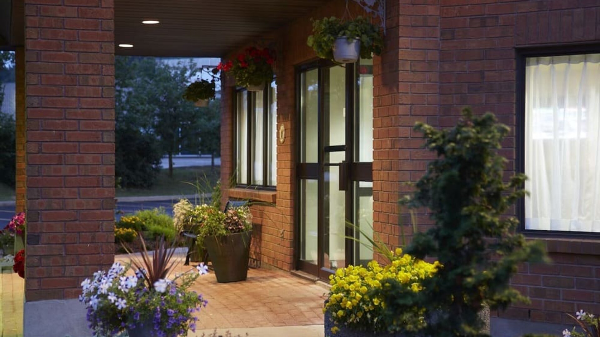 Welcoming front entrance surrounded by landscaped gardens at Comfort Inn Laval.