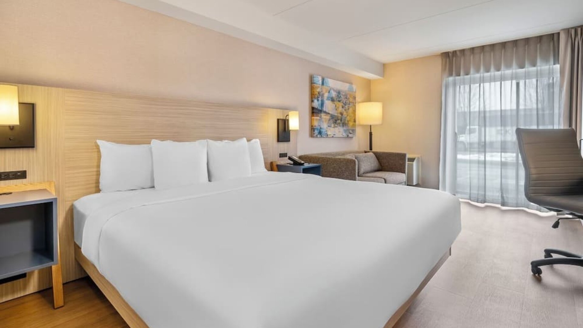 Bright king guest room with contemporary furnishings and spacious layout at Comfort Inn Laval.
